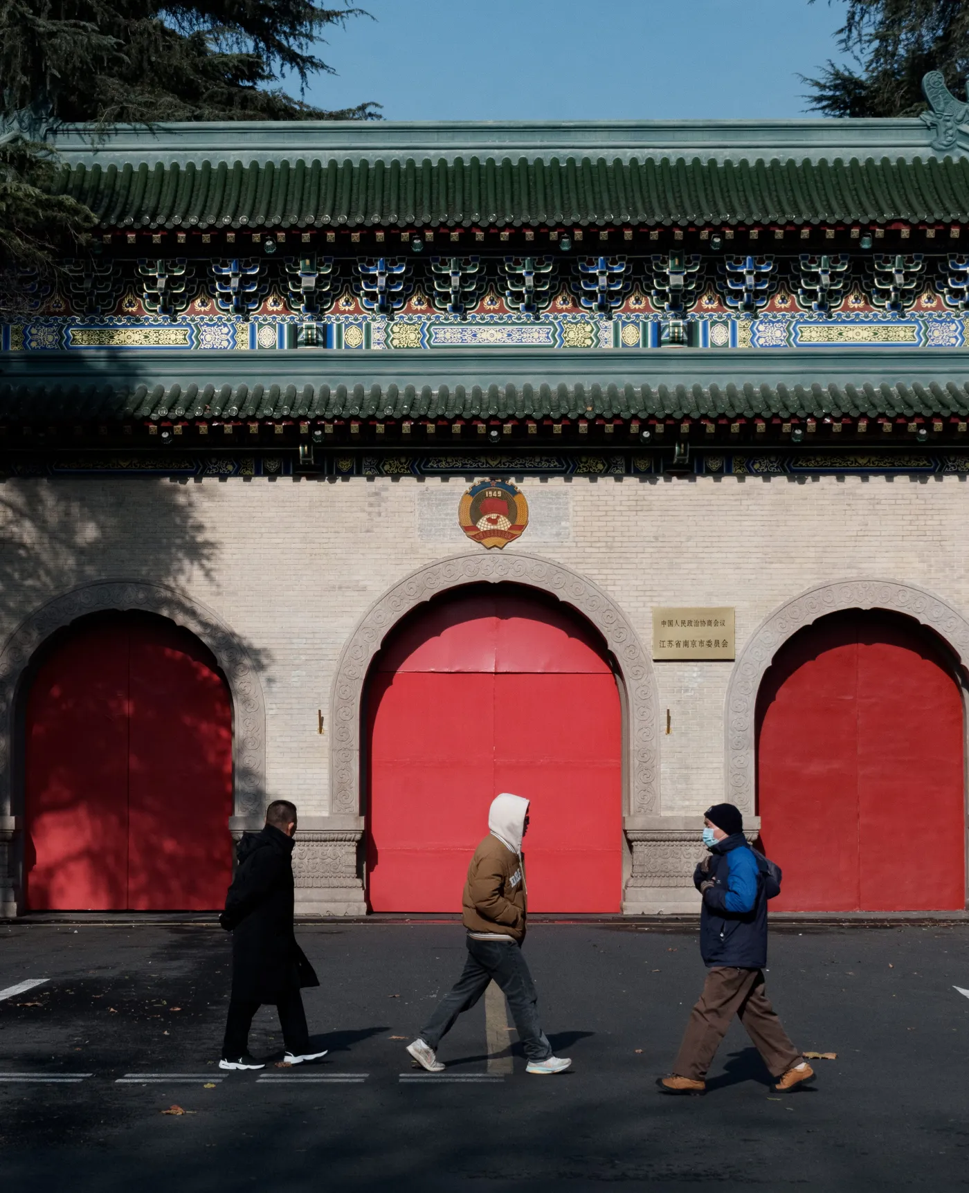 红漆宫门与路过的行人
